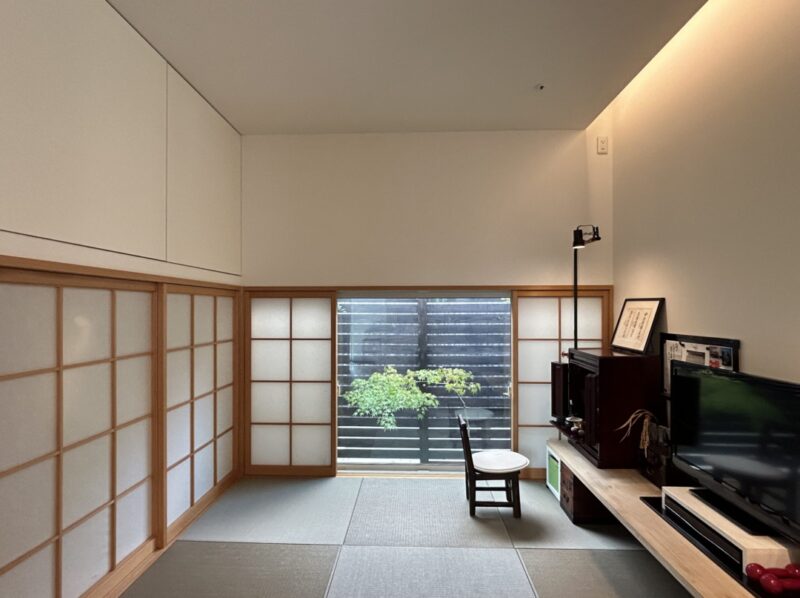 デザインにこだわったミニマムモダンの平屋の内観写真。LDKと繋がる和室　間接照明を採用して、天井がスッキリ